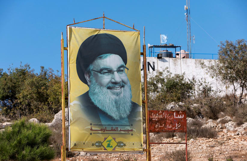  EL LÍDER DE HEZBOLLAH Sayyed Hassan Nasrallah sonríe con suficiencia desde un cartel en Marwahin, al sur del Líbano. (photo credit: AZIZ TAHER/REUTERS)