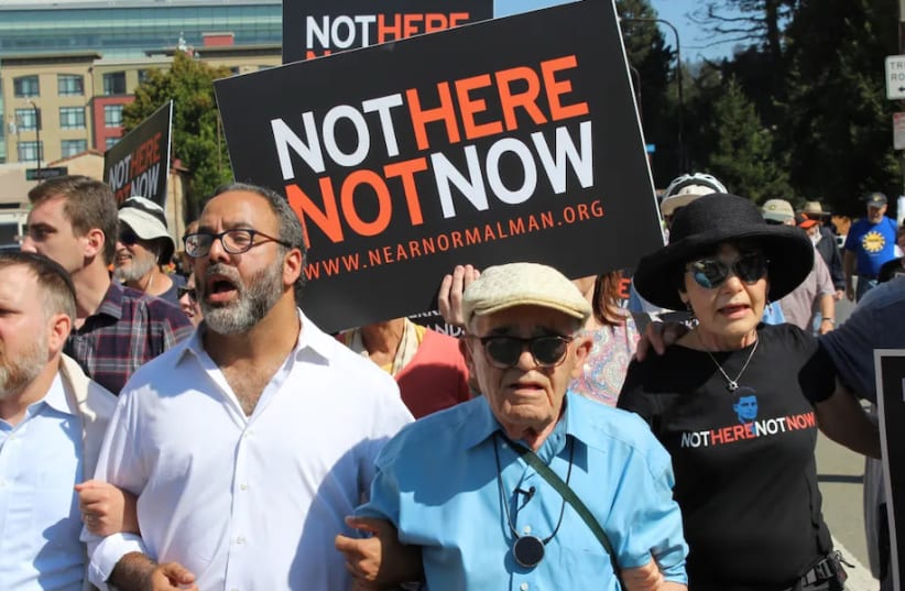 Holocaust survivor Ben Stern (blue shirt) leads 200 marchers in the "Bay Area Rally Against Hate" in Berkeley in August 2017. He is linking arms with his daughter Charlene Stern and Rabbi Menachem Creditor; Rabbi Yonatan Cohen of Congregation Beth Israel in Berkeley is at far left.  (photo credit: (Rob Gloster/J.))