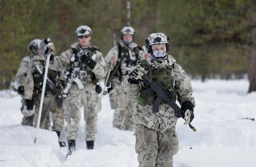  Miembros del ejército caminan por la nieve mientras tropas finlandesas y suecas participan en el ejercicio Nordic Response 24 de la OTAN cerca de Hetta, Finlandia, el 5 de marzo de 2024. (photo credit: Leonhard Foeger/Reuters)