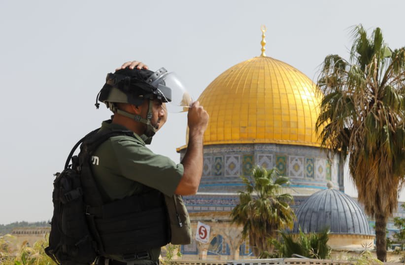  Un agente de seguridad israelí observa la Cúpula de la Roca en el Monte del Templo de Jerusalén. (photo credit: MARC ISRAEL SELLEM/THE JERUSALEM POST)