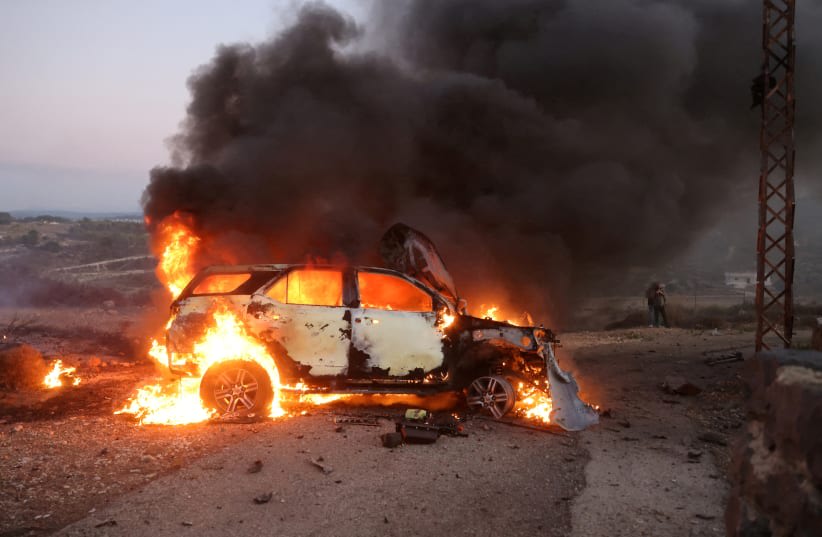  El coche de un periodista arde en el lugar donde el videoperiodista de Reuters Issam Abdallah murió y otras seis personas resultaron heridas el viernes cuando misiles disparados desde la dirección de Israel les alcanzaron, en Alma Al-Shaab, cerca de la frontera con Israel, sur de Líbano, 13 de octu (photo credit: REUTERS/THAIER AL-SUDANI)