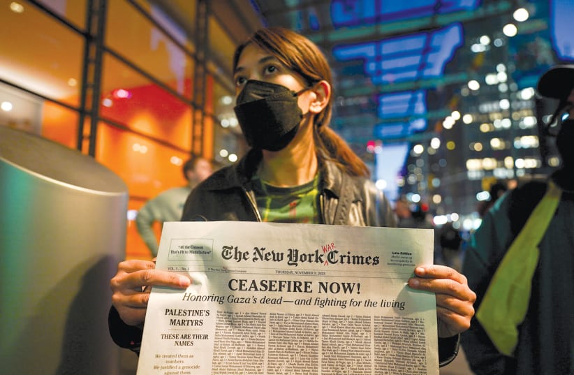  A protester holds a mock newspaper with a list of people killed in Gaza at a pro-Palestinian rally outside ‘The New York Times’ building in New York City on November 9, 2023.  (photo credit: David Dee Delgado/Reuters)