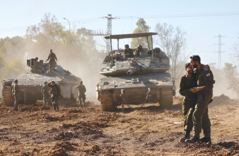  Israeli soldiers embrace after returning from the Gaza Strip, amid the ongoing conflict between Israel and Hamas, in southern Israel, February 29, 2024 (photo credit: AMIR COHEN/REUTERS)