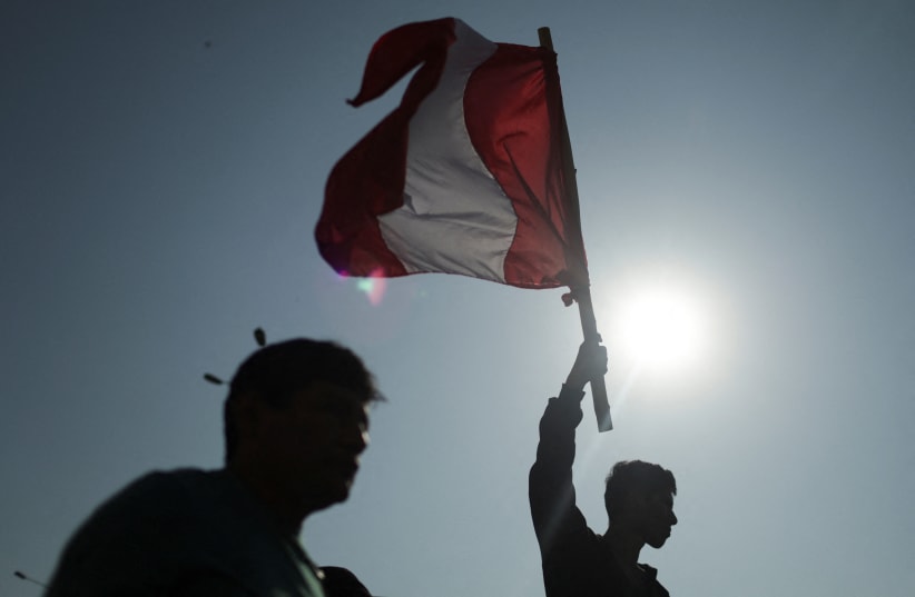  A man holds a Peru flag during an anti-government demonstration in Lima, Peru January 24, 2023. (photo credit: REUTERS/PILAR OLIVARES)