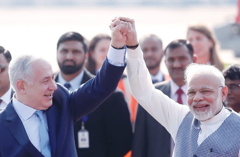  EL PRIMER MINISTRO Benjamín Netanyahu y su homólogo indio, Narendra Modi, levantan sus brazos a la llegada de Netanyahu a la Estación de la Fuerza Aérea Palam en Nueva Delhi, en 2018. (photo credit: Adnan Abidi/Reuters)