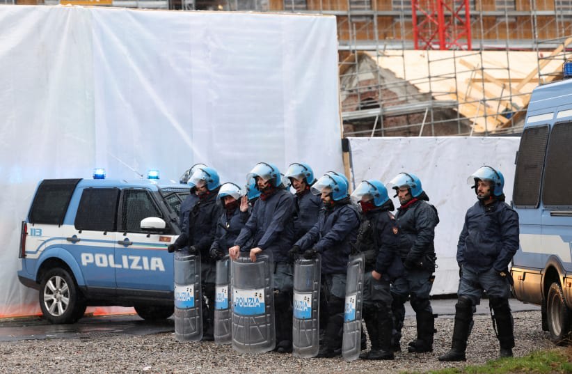  Agentes de policía montan guardia junto a las obras de construcción de la Villa Olímpica de Invierno, durante una manifestación contra los Juegos Olímpicos de Invierno de Milán Cortina 2026, en Milán, Italia, el 10 de febrero de 2024. (photo credit: Claudia Greco/Reuters)