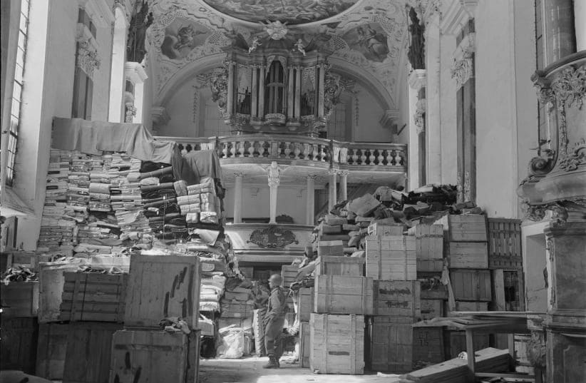  Foto de archivo de un soldado estadounidense contemplando obras de arte robadas por el régimen nazi y almacenadas en la iglesia de Ellingen, Alemania. (photo credit: REUTERS)