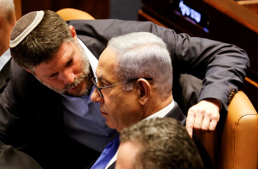  Israeli Finance Minister Bezalel Smotrich speaks with Prime Minister Benjamin Netanyahu as lawmakers gather at the Knesset plenum to vote on a bill that would limit some Supreme Court power, in Jerusalem July 24, 2023.  (photo credit: AMIR COHEN/REUTERS)