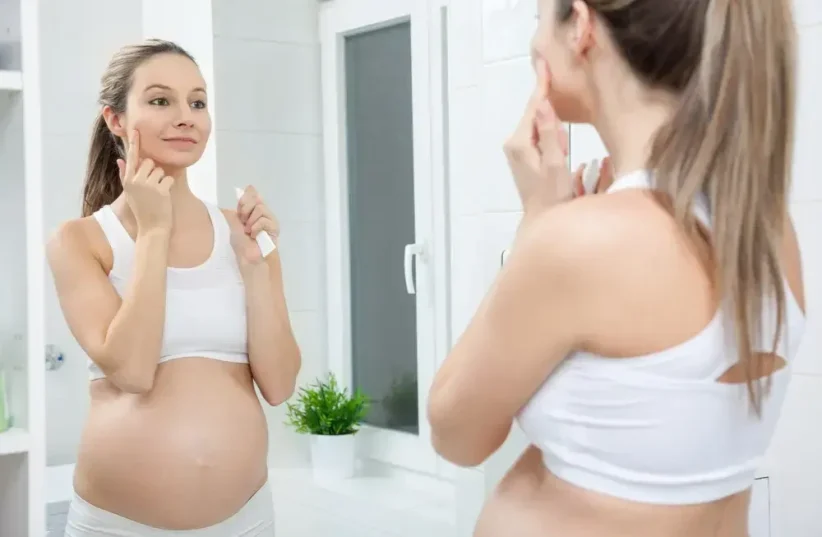   Without retinol and silicic acid. A pregnant woman applies cream  (photo credit: SHUTTERSTOCK)