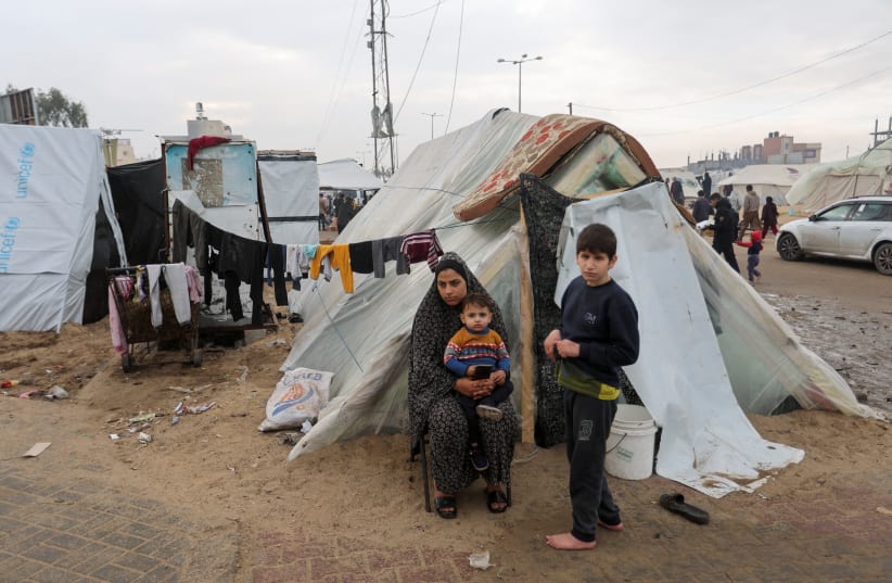  Displaced Palestinians, who fled their houses due to Israeli strikes, shelter in a tent camp, amid the ongoing conflict between Israel and the Palestinian Islamist group Hamas, in Rafah in the southern Gaza Strip, December 25, 2023. (photo credit: REUTERS/IBRAHEEM ABU MUSTAFA)