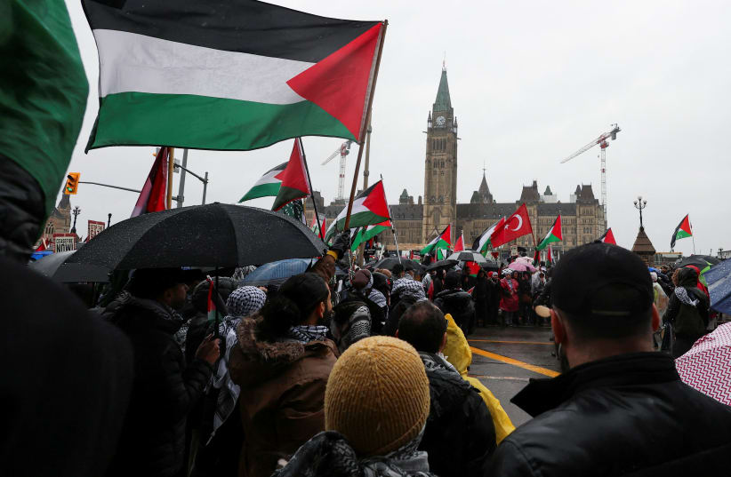  Protesters hold Palestinian flags during a rally to call for a ceasefire, amid the ongoing conflict between Israel and the Palestinian Islamist group Hamas in Gaza, on Parliament Hill in Ottawa, Ontario, Canada March 9, 2024. (photo credit: REUTERS/Ismail Shakil)