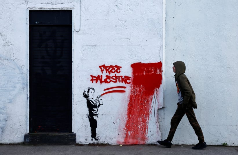  A man walks past graffiti reading 'Free Palestine', amid the ongoing conflict between Israel and the Palestinian Islamist group Hamas, in Dublin, Ireland, November 15, 2023. (photo credit: REUTERS/CLODAGH KILCOYNE)