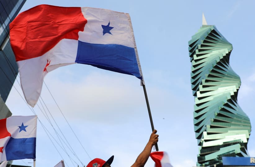  A person holds a flag, after Panama's top court ruled unconstitutional a mining contract with Canadian miner First Quantum to operate a copper mine in the country, following weeks of protests against the deal, in Panama City, Panama, November 28, 2023. (photo credit: REUTERS/Aris Martinez)