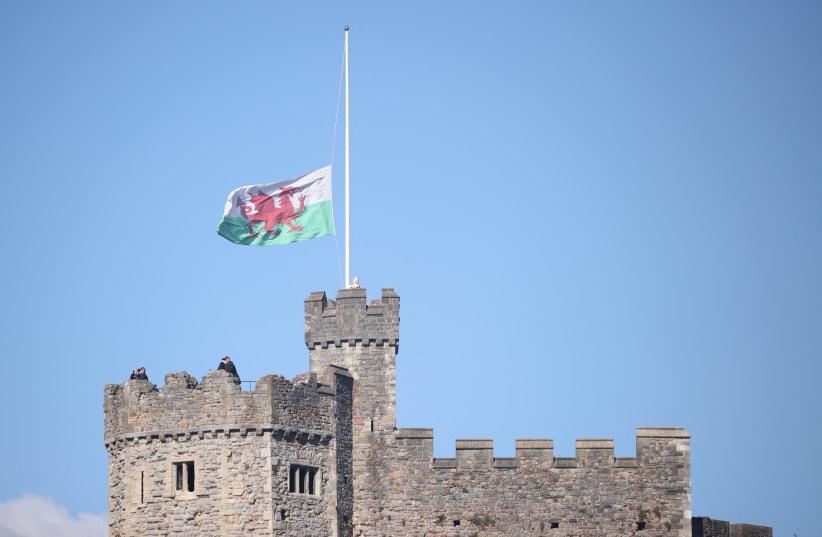  A Welsh flag flies at half mast at Cardiff Castle, following the death of Britain's Queen Elizabeth, in Cardiff, Wales, Britain, September 16, 2022. (photo credit: REUTERS/MOLLY DARLINGTON)