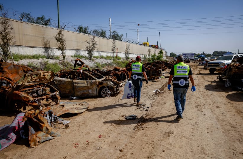  Personal de Zaka trabaja en un campo con coches destruidos de la masacre del 7 de octubre, cerca de la frontera entre Israel y Gaza, 23 de noviembre de 2023. (photo credit: Chaim Goldberg/Flash90)
