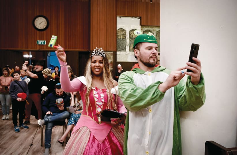  MEGILLAT ESTHER se lee -con la asistencia de una reina disfrazada- en la víspera de Purim de 2023, en la Gran Sinagoga de Tel Aviv. (photo credit: AVSHALOM SASSONI/FLASH90)