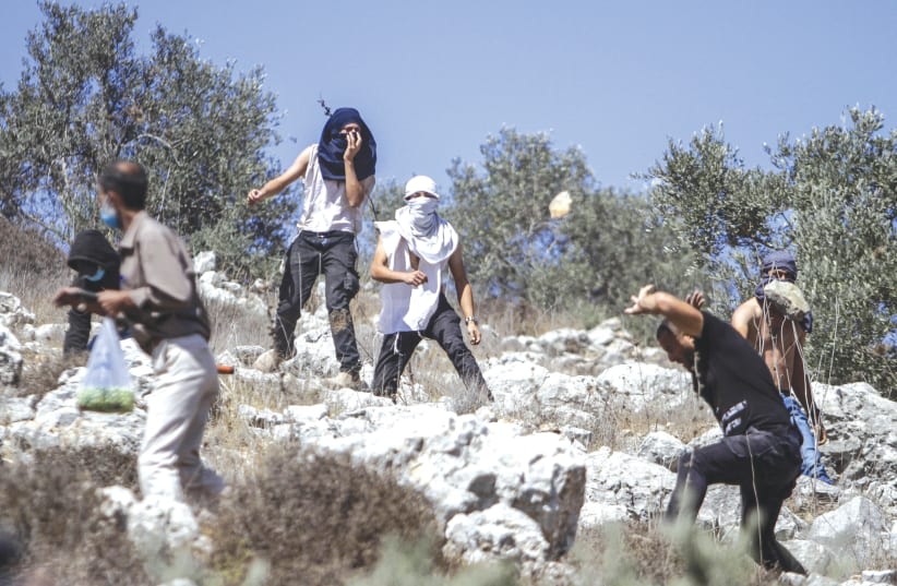  Colonos lanzan piedras contra palestinos durante la temporada anual de cosecha, cerca del asentamiento de Yitzhar en 2020. (photo credit: NASSER ISHTAYEH/FLASH90)