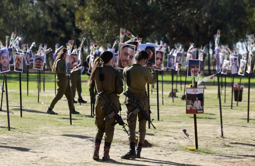  SOLDIERS PAY their respects at the Nova music festival site in November. ‘Beyond the sounds of the shofar, guns, music, prayers, livestock, and bombs, I also heard the whispers,’ says the writer.  (photo credit: MENAHEM KAHANA / AFP)
