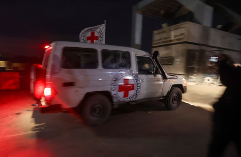  Un vehículo de la Cruz Roja que transporta rehenes secuestrados por Hamás durante el ataque del 7 de octubre contra Israel, llega a la frontera de Rafah, en medio de un acuerdo de intercambio de rehenes y prisioneros entre Hamás e Israel, en el sur de la Franja de Gaza, 28 de noviembre de 2023. (photo credit: REUTERS/IBRAHEEM ABU MUSTAFA)