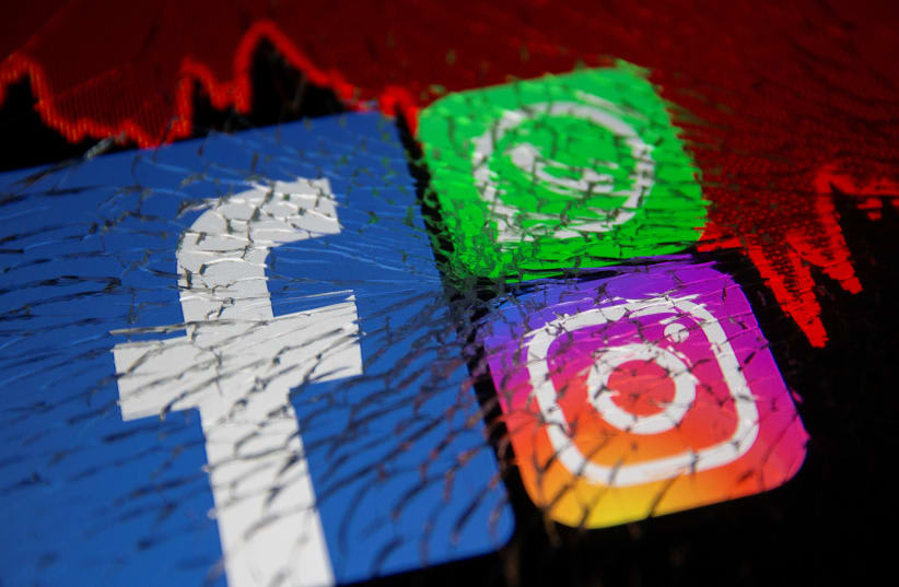 Los logotipos de Facebook, Whatsapp e Instagram y el gráfico de acciones se muestran a través de un cristal roto en esta ilustración tomada el 4 de octubre de 2021. (photo credit: REUTERS/DADO RUVIC)