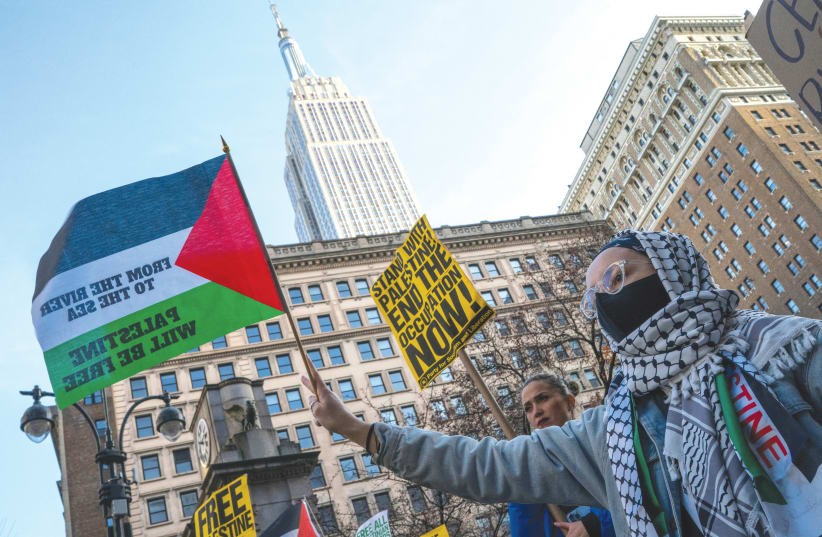  EN UNA protesta en Nueva York en diciembre, una bandera lleva el lema "Del río al mar, Palestina será libre". Personas aparentemente inteligentes resucitan el engaño de la solución de los dos Estados, mientras ignoran los incesantes gritos a favor de la solución de un solo Estado, argumenta el escr (photo credit: Eduardo Munoz/Reuters)