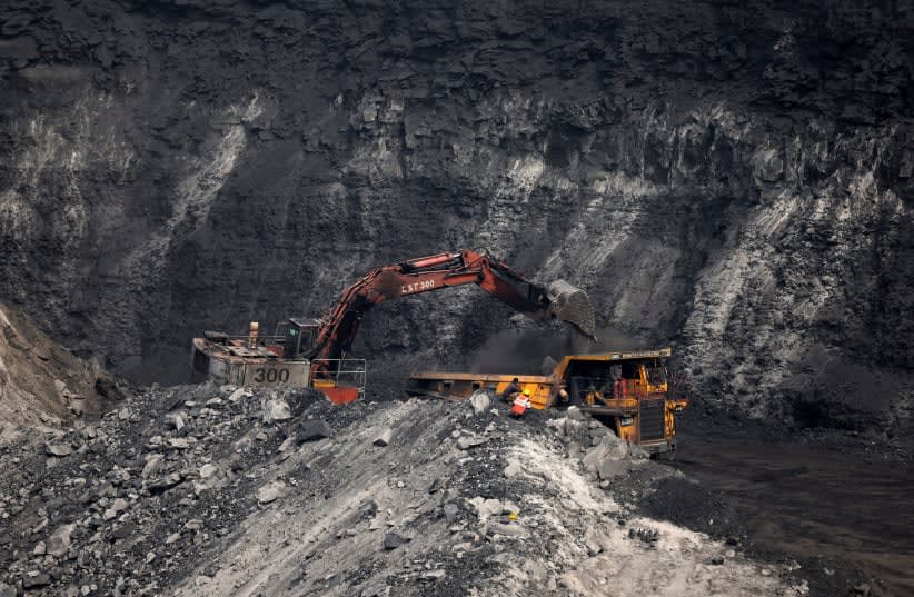  Un cargador carga carbón en el camión en un yacimiento de carbón a cielo abierto en la mina de carbón de Topa, en el distrito de Ramgarh, en el estado oriental indio de Jharkhand, India, 27 de febrero de 2024. (photo credit: REUTERS/AMIT DAVE)