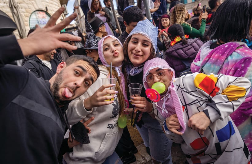  Purim revelers in Jerusalem's Nahlaot neighborhood in 2023. (photo credit: FLASH90)