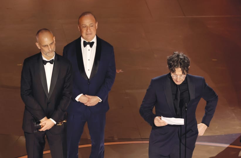  BRITISH-JEWISH FILMMAKER Jonathan Glazer (R) reads his Oscar acceptance speech in Hollywood, Mar. 10.  (photo credit: KEVIN WINTER/GETTY IMAGES)