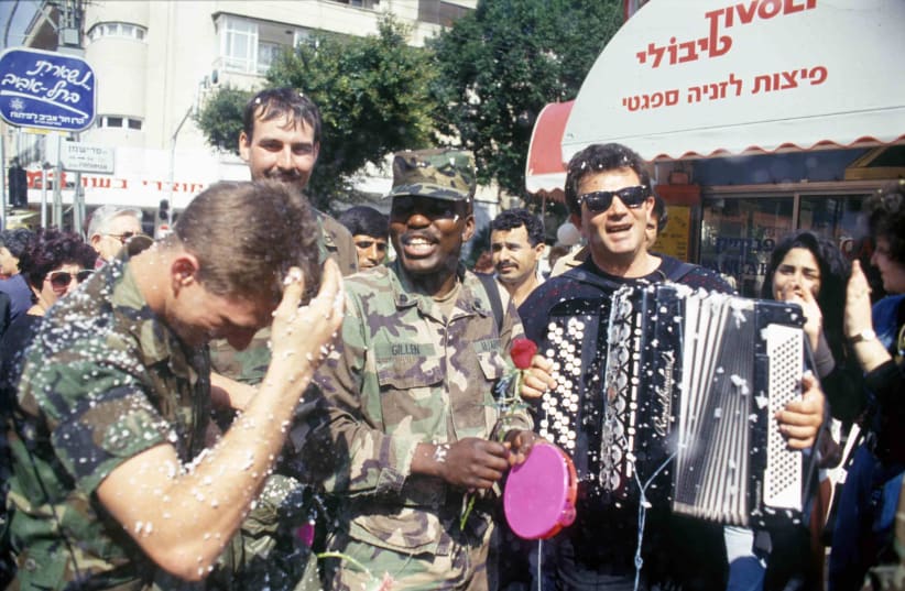  US soldiers celebrate Purim and the end of the Gulf War on the streets of Tel Aviv as children spray snow foam and Israelis play music. February 1991.  (photo credit: Alex Levac, IDF archive)
