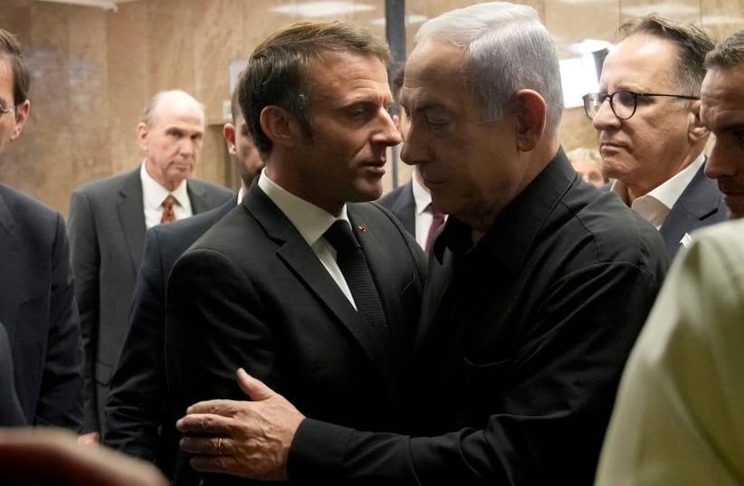  Israeli Prime Minister Benjamin Netanyahu and French President Emmanuel Macron embrace following a joint press conference, amid the Israeli-Hamas conflict, in Jerusalem, October 24, 2023.  (photo credit: CHRISTOPHE ENA/REUTERS)