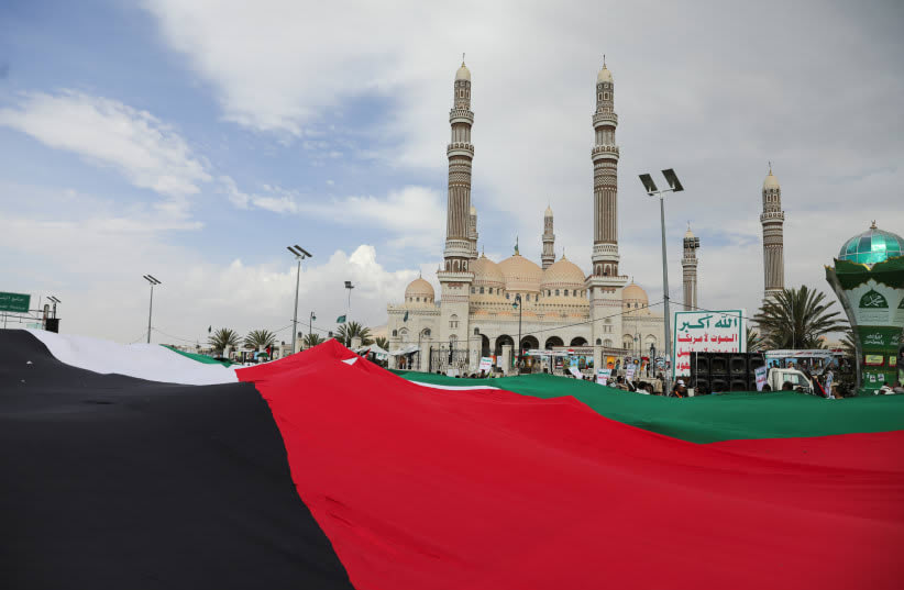  Manifestantes, en su mayoría partidarios de los Houthi, portan una bandera palestina durante una concentración en solidaridad con los palestinos de la Franja de Gaza, en Saná, Yemen, 8 de marzo de 2024. (photo credit: KHALED ABDULLAH/REUTERS)