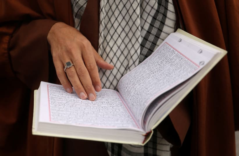  Un clérigo iraní lee el Corán en el santuario de Abdol-Azim, durante el mes sagrado del Ramadán en Teherán, Irán, 25 de marzo de 2024. (photo credit: Majid Asgaripour/West Asia News Agency/Reuters)