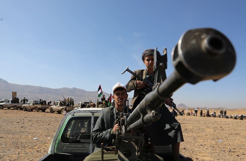  Un miembro de una tribu leal a los Houthis maneja una ametralladora montada en una camioneta durante un desfile militar para nuevos reclutas tribales en medio de la escalada de tensiones con la coalición liderada por Estados Unidos en el Mar Rojo, en Bani Hushaish, Yemen, 22 de enero de 2024. (photo credit: KHALED ABDULLAH/REUTERS)