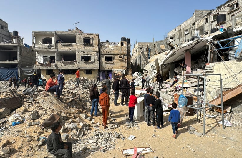  Palestinos inspeccionan el lugar de un ataque israelí, en medio del actual conflicto entre Israel y el grupo terrorista palestino Hamás, en Rafah, en el sur de la Franja de Gaza, 27 de marzo de 2024. (photo credit: BASSAM MASOUD/REUTERS)