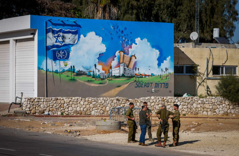 Israeli soldiers standing near a graffiti at the site of the Old Sderot Police Station that was attacked by Hamas terrorists on October 7, 2023, in the southern Israeli city of Sderot, March 11, 2024. (photo credit: Chaim Goldberg/Flash90)