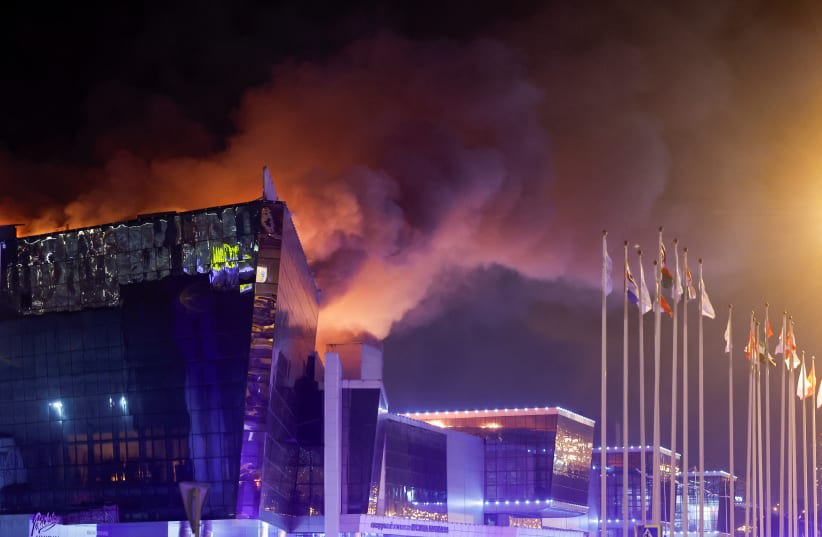 El humo se eleva por encima de la sala de conciertos Crocus City Hall en llamas tras un tiroteo, en las afueras de Moscú, Rusia, 22 de marzo de 2024. (photo credit: MAXIM SHEMETOV/REUTERS)