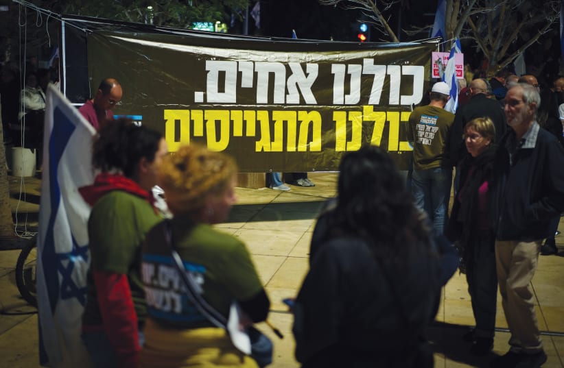  A poster at a Tel Aviv protest reads in Hebrew, "We are all brothers. We are all drafted." (photo credit: ERIK MARMOR/FLASH90)