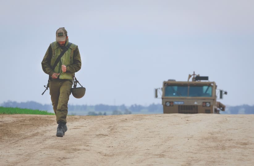  A SOLDIER walks near an IDF Artillery Corps staging area on the  border with Gaza (photo credit: MOSHE SHAI/FLASH90)
