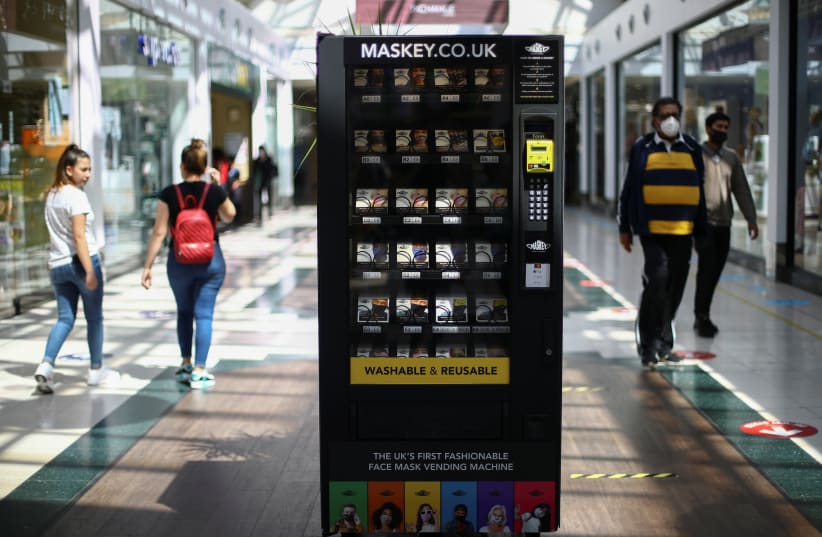 A vending machine that sells protective masks is seen in a shopping centre, following the coronavirus disease (COVID-19) outbreak, in Ilford, London, Britain July 29, 2020.  (photo credit: Hannah McKay/Reuters)