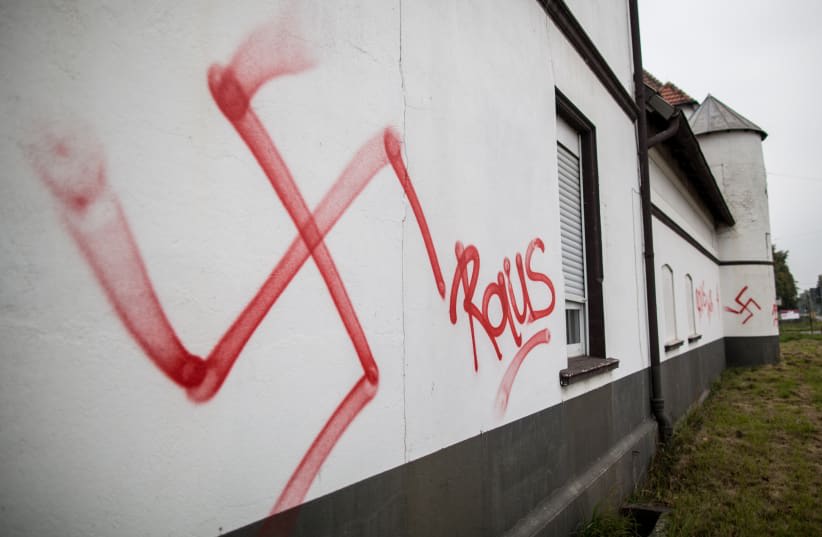 Esvástica y la palabra "Raus" (Fuera) son rociadas en un alojamiento para solicitantes de asilo en Waltrop, oeste de Alemania, el 13 de octubre de 2015. (photo credit: AFP PHOTO)