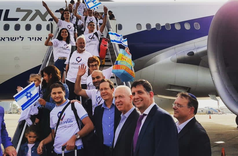  El presidente de la Agencia Judía para Israel, Isaac Herzog, y el presidente de Keren Hayesod, Sam Grundwerg, posan con inmigrantes franceses al desembarcar de su vuelo de aliá. (photo credit: AVI HAYUN/KEREN HAYESOD)