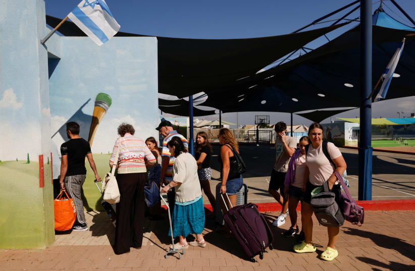  La gente hace cola mientras los israelíes son evacuados de la ciudad sureña de Sderot, cerca de la frontera de Israel con Gaza, 15 de octubre de 2023. (photo credit: REUTERS/AMIR COHEN)