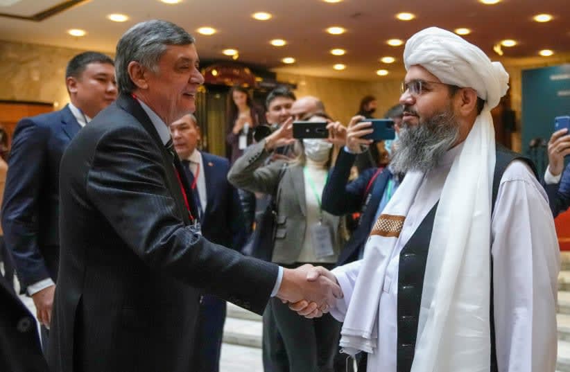  El enviado presidencial ruso a Afganistán Zamir Kabulov estrecha la mano de un representante de la delegación talibán Mawlawi Shahabuddin Dilawar antes del comienzo de las conversaciones internacionales sobre Afganistán en Moscú, Rusia, 20 de octubre de 2021. (photo credit: ALEXANDER ZEMLIANICHENKO/REUTERS)