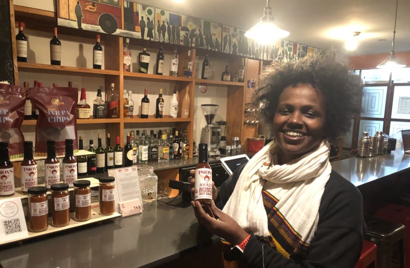  Tsion Café owner Eejhy Barhany displays traditional Ethiopian sauce she makes and sells in the eatery. (photo credit: HOWARD BLAS)