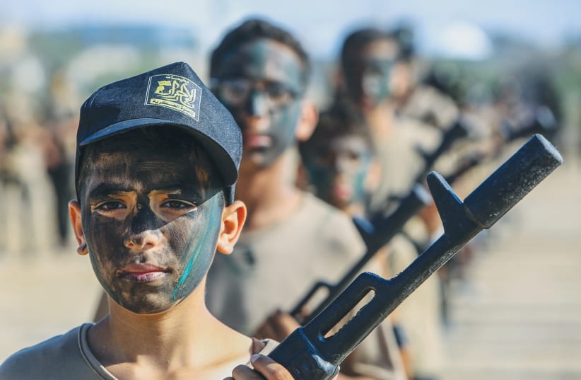  YOUNG PALESTINIANS take part in a summer camp organized by the Islamic Jihad, in Khan Yunis, southern Gaza Strip, last year. There is no comparison between this and young Israelis who dress in Purim costume as IDF soldiers, the writer stresses.  (photo credit: ABED RAHIM KHATIB/FLASH90)