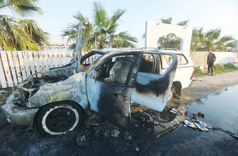  Una PERSONA observa el vehículo calcinado en el que murieron siete empleados de World Central Kitchen en un ataque aéreo en la zona de Deir al-Balah, en la Franja de Gaza, la semana pasada. (photo credit: Ahmed Zakot/Reuters)