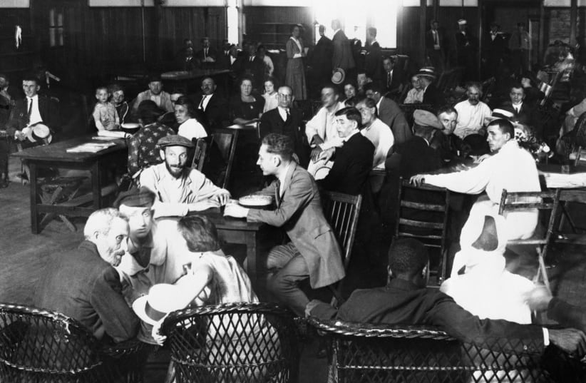 Immigrants awaiting approval of their entry into the U. S. crowd the lunchroom for their noonday meal at Ellis Island, 1923. The next year the U.S. would adopt legislation severely restricting immigration. (photo credit:  (Bettmann/Getty Images))