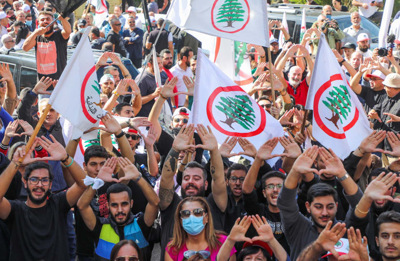  Simpatizantes del partido Fuerzas Libanesas Cristianas gesticulan durante una protesta contra la citación del líder del partido, Samir Geagea, para una audiencia con los servicios de inteligencia del ejército por la violencia callejera de este mes en Beirut, en Maarab, Líbano, 27 de octubre de 2021 (photo credit: MOHAMED AZAKIR/REUTERS)