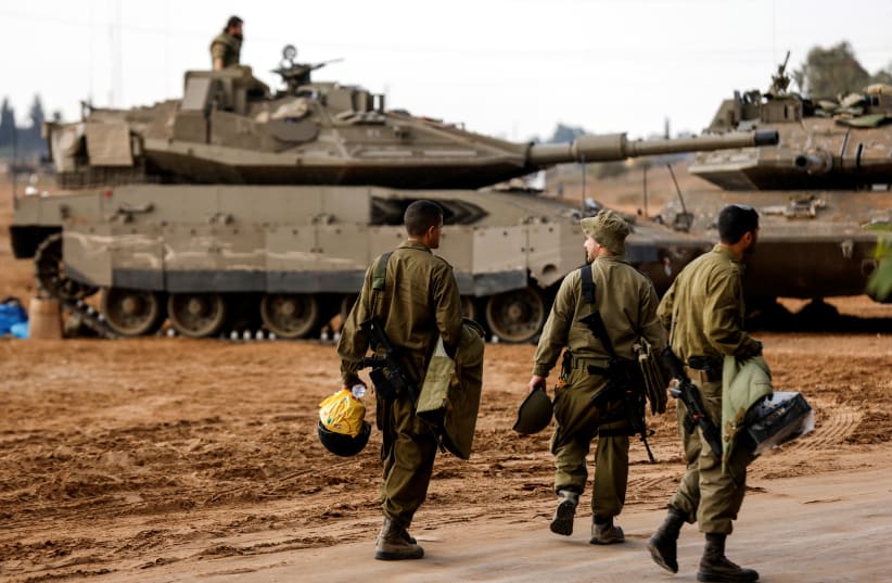  Soldados israelíes caminan junto a tanques israelíes cerca de la frontera de Israel con la Franja de Gaza, en el sur de Israel el 15 de octubre de 2023. (photo credit: REUTERS/AMIR COHEN)