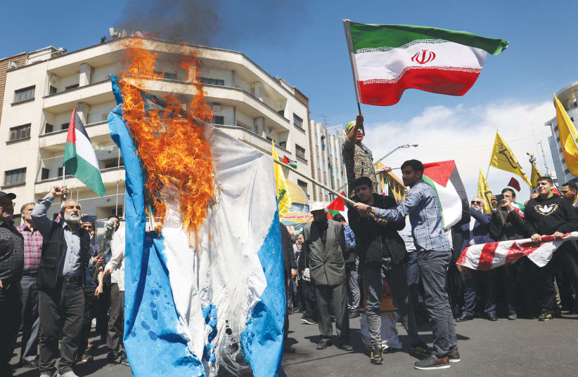  IRANÍES QUEMAN una bandera israelí durante una manifestación en Teherán el viernes, Día de Al Quds. La apariencia de agresividad que proyecta el gobierno iraní parece cada vez más una fachada que un reflejo de auténtica fortaleza, afirma el escritor. (photo credit: WEST ASIA NEWS AGENCY/REUTERS)